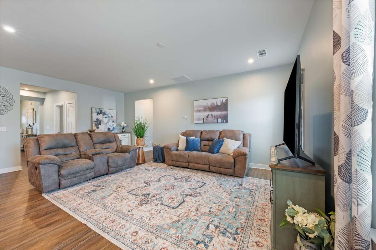 An expansive living room provides versatile space for both lively gatherings and comfortable everyday relaxation.