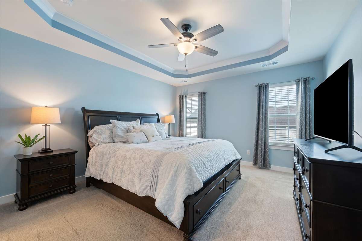The first floor primary bedroom features a tray ceiling, large windows, and an en-suite!