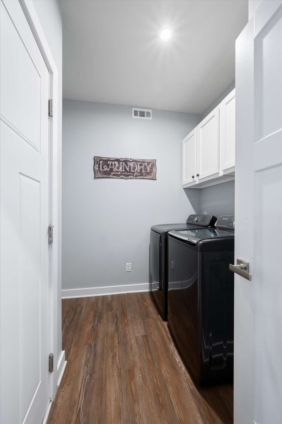 The laundry room connects the entry hall to the garage.  Extra cabinets have been added to provide even more storage.