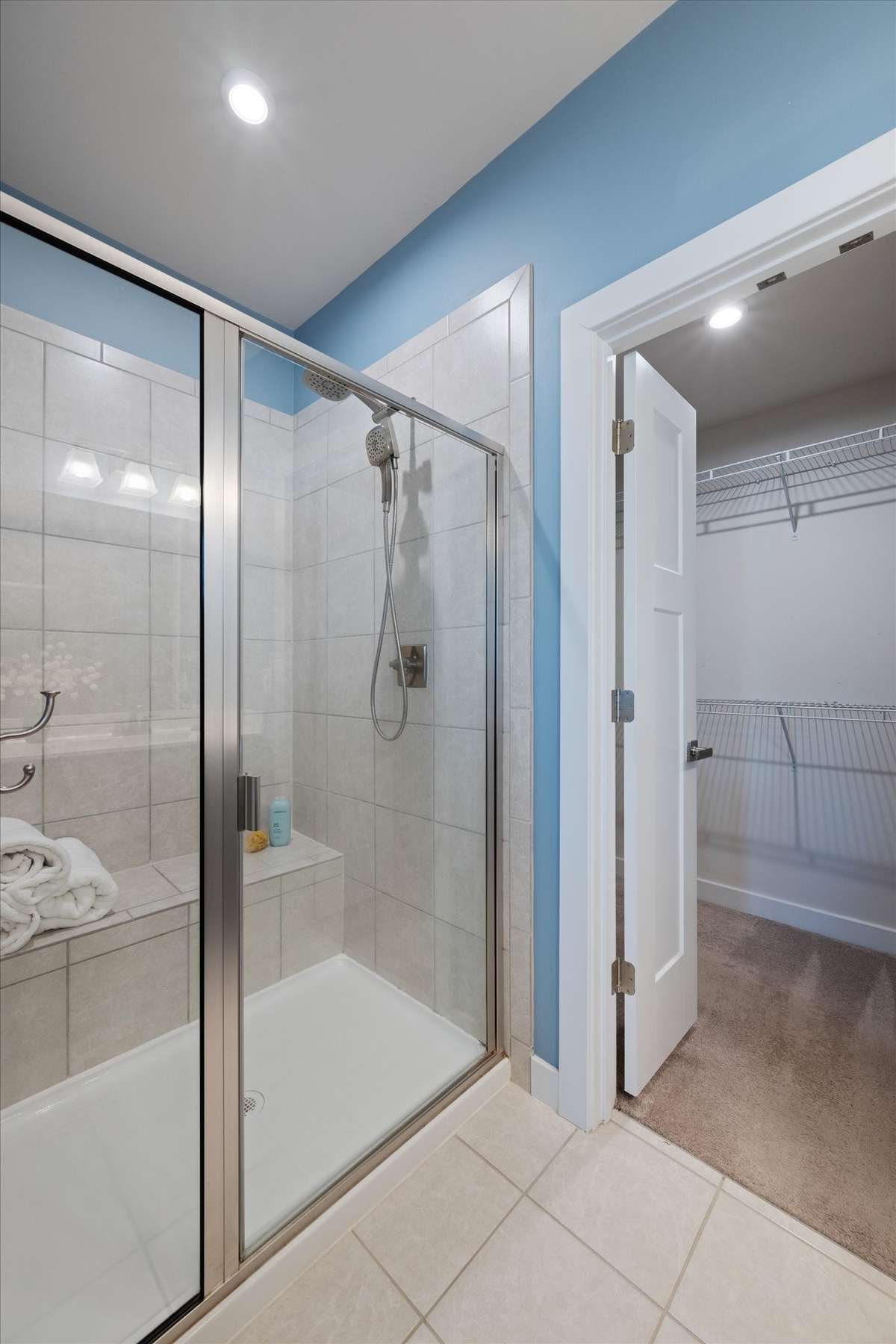 The oversized shower includes a bench upgrade.  Walk-in closet can be seen to the right.
