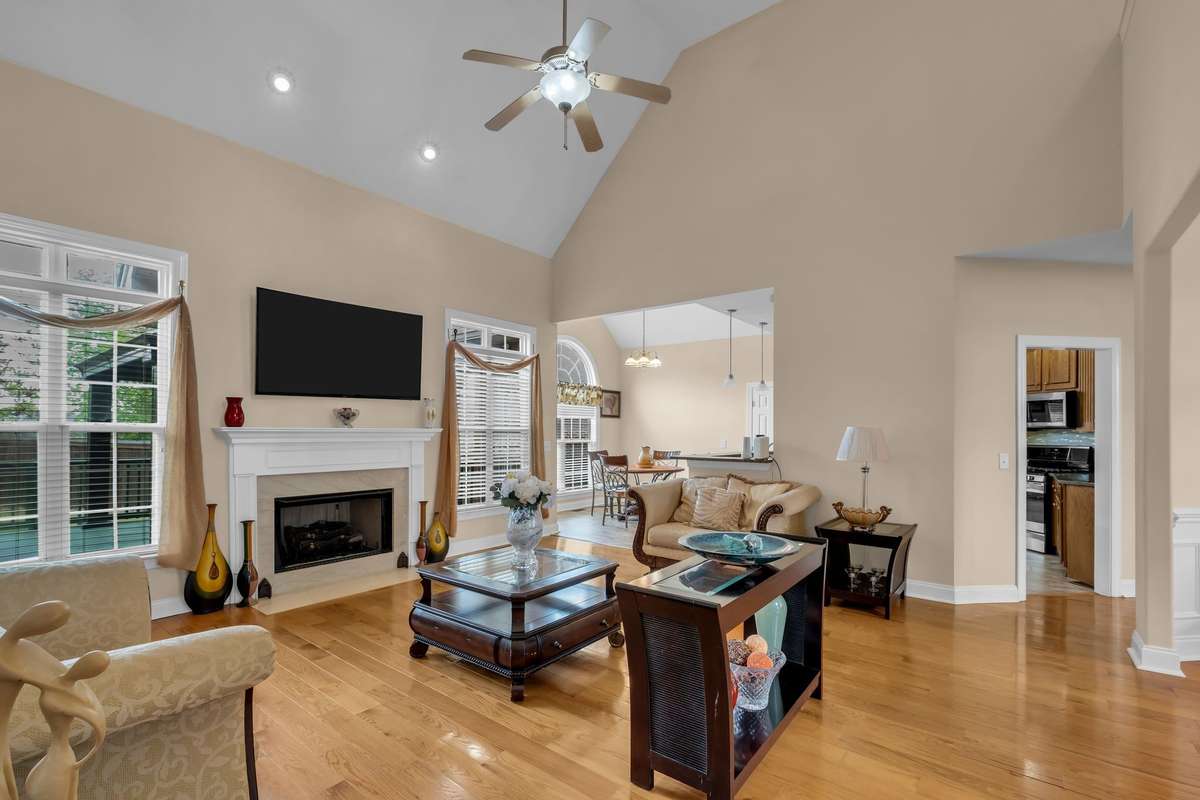 Family room with hardwood floors, high ceilings, fireplace with gas logs is open to the kitchen area and dining room.
