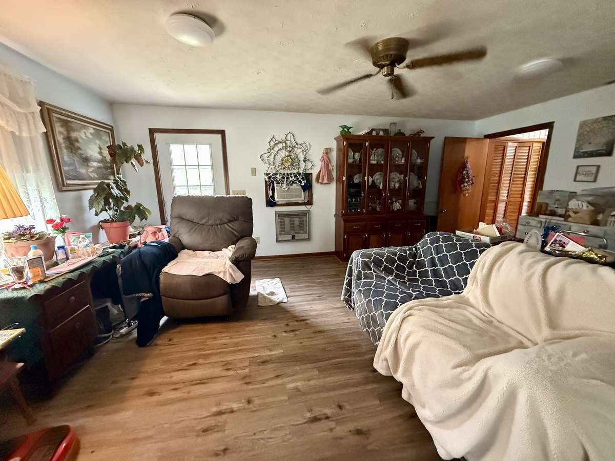 Separate den with viny flooring, ceiling fan and door leading to back yard.