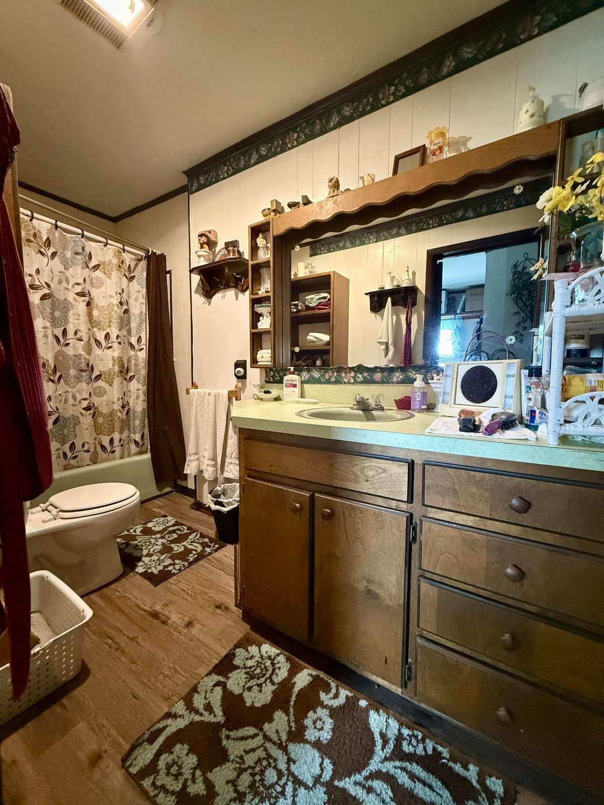 Second bathroom with vinyl flooring, large single vanity and shower/tub combo.