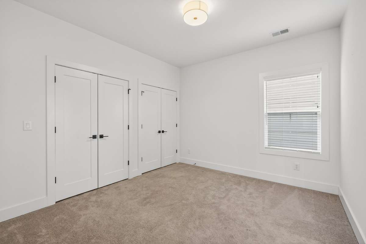 Secondary Bedroom features two closets and access to a Jack-and-Jill bathroom with tub/shower combination, double vanity and tile floors.