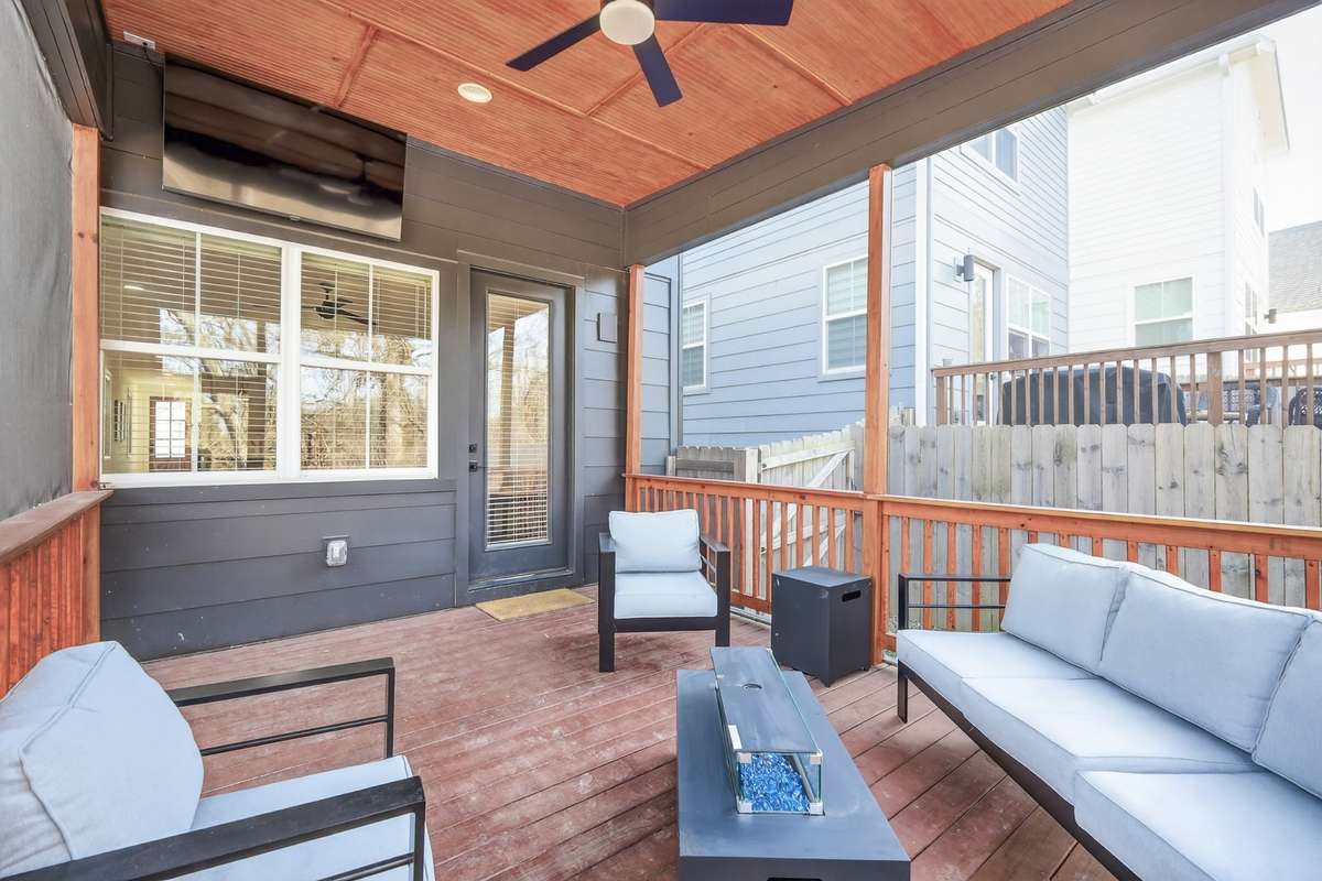 Covered deck with screened in area. Ceiling fan and built-in television. From here you can access the back yard that features a fire pit and area for a grill. The back yard has a privacy fence.