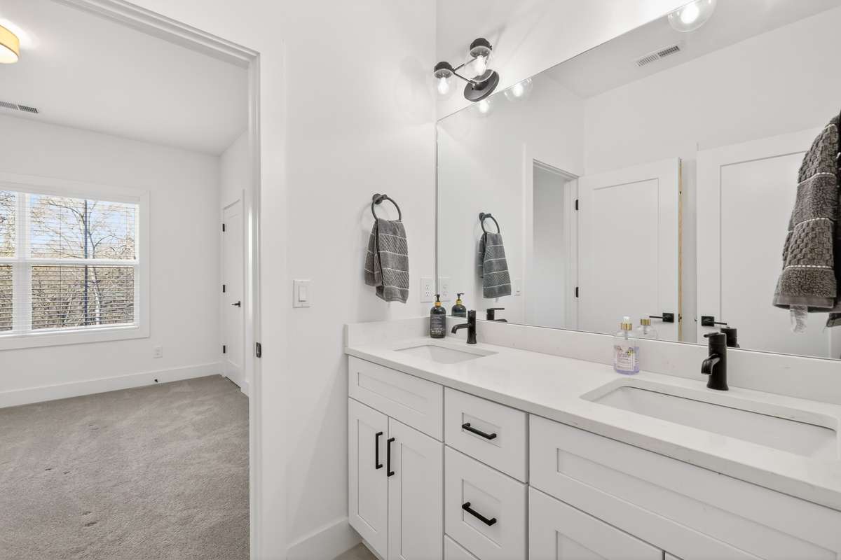 Secondary Bedroom features two closets and access to a Jack-and-Jill bathroom with tub/shower combination, double vanity and tile floors.