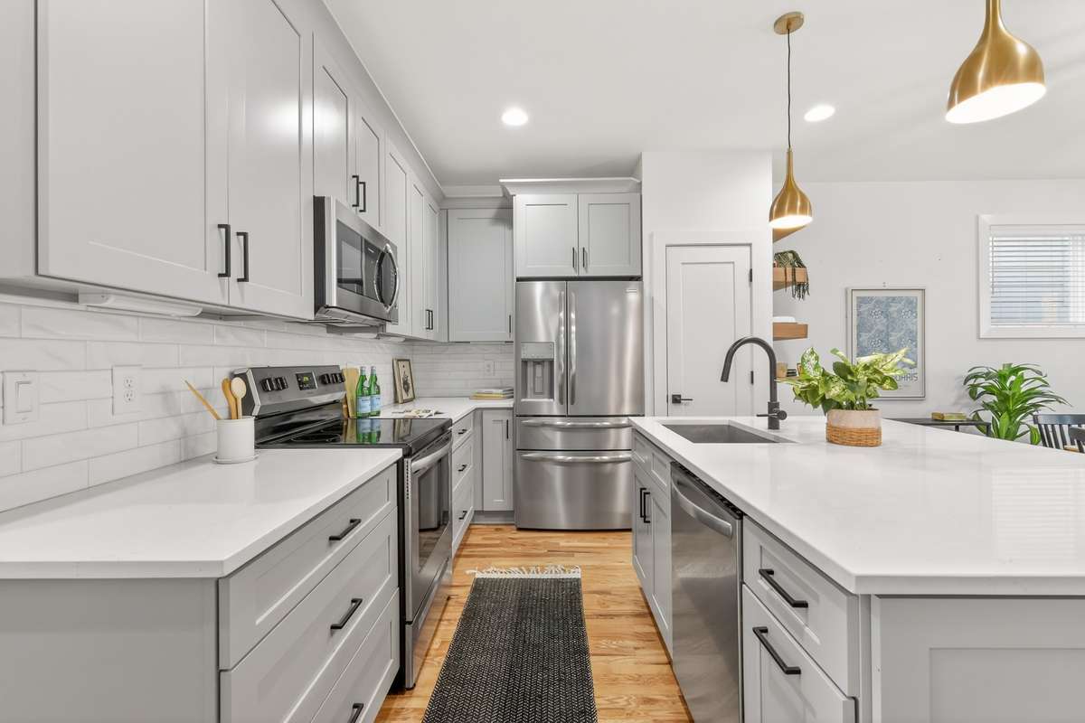 Open concept kitchen with soft-close cabinets, stainless steel appliances and large kitchen island with seating for three. French door 2 drawer refrigerator with water and icemaker in the door. Garbage disposal.