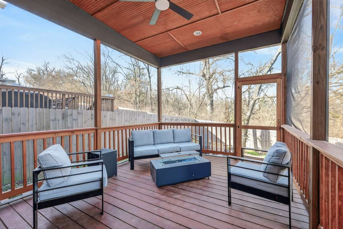 Covered deck with screened in area. Ceiling fan and built-in television. From here you can access the back yard that features a fire pit and area for a grill. The back yard has a privacy fence.