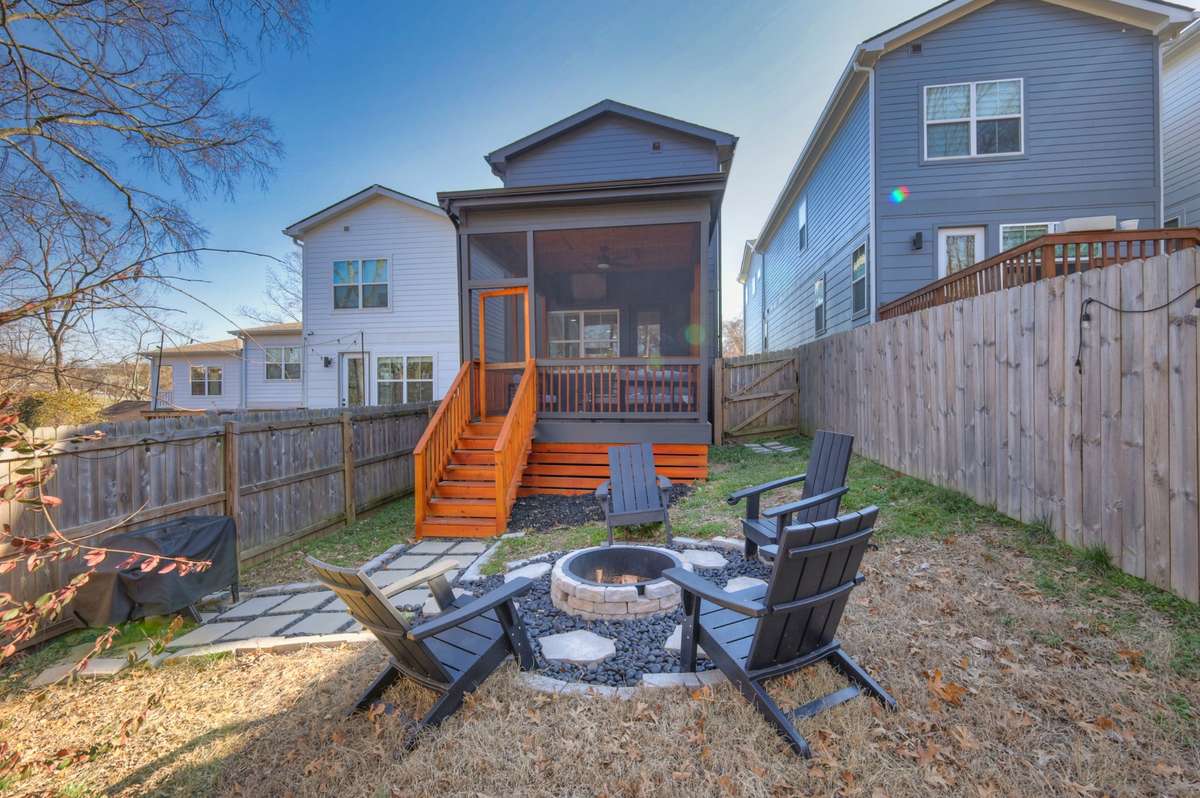 The back yard that features a fire pit and area for a grill. The back yard has a privacy fence. There is also a gate on the side of the house to access the back yard.