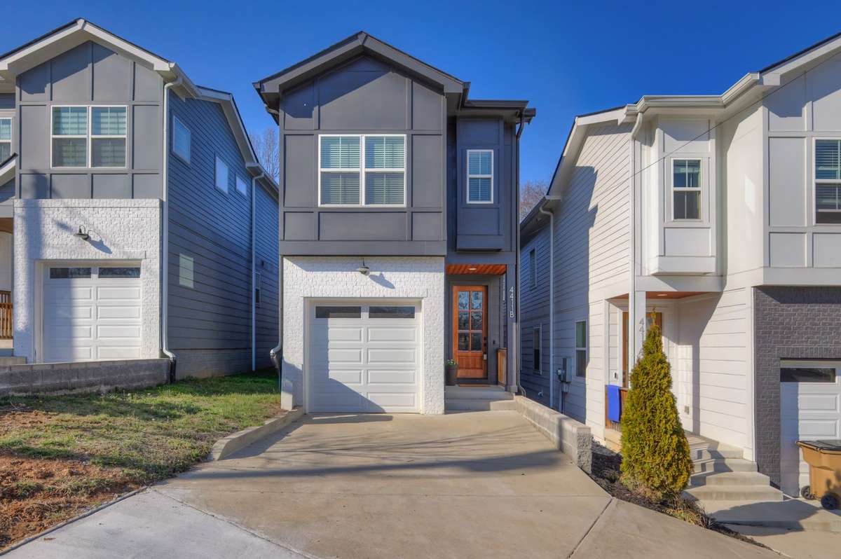 Front of the home with small covered entry landing. Home is fiber cement board and partial brick.