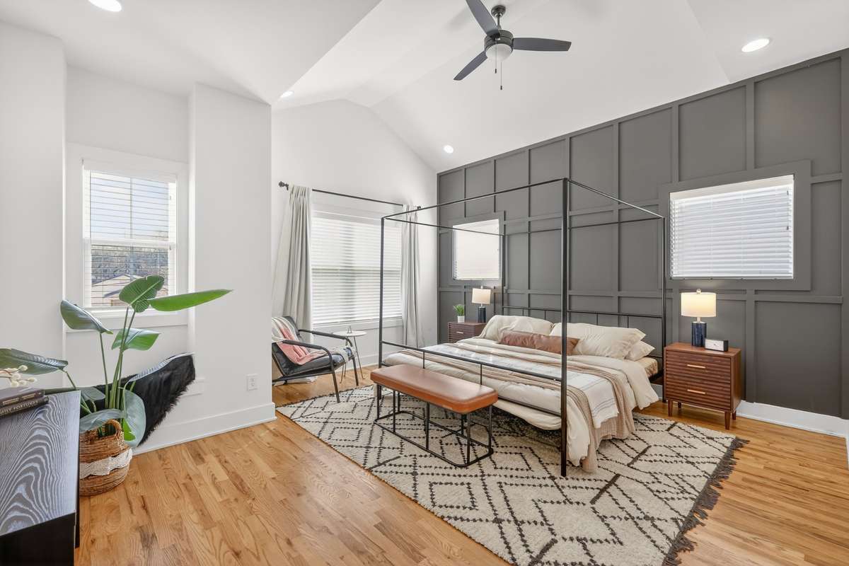 Primary Bedroom Ensuite w/vaulted ceiling, tons of natural light, recessed lighting and ceiling fan. Custom trim accent wall. Hardwood floors that lead into a private bath with double vanity and walk-in glass shower. Large walk-in closet. 4 windows.