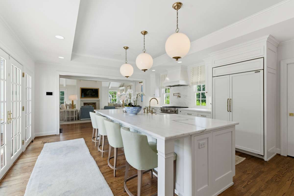 This kitchen has it all - marble counters, inset cabinets, top of the line appliances + pot filler, beautiful hardware and lighting, storage galore, doors to the outside and opens to a family room and covered porch for meals al fresco!