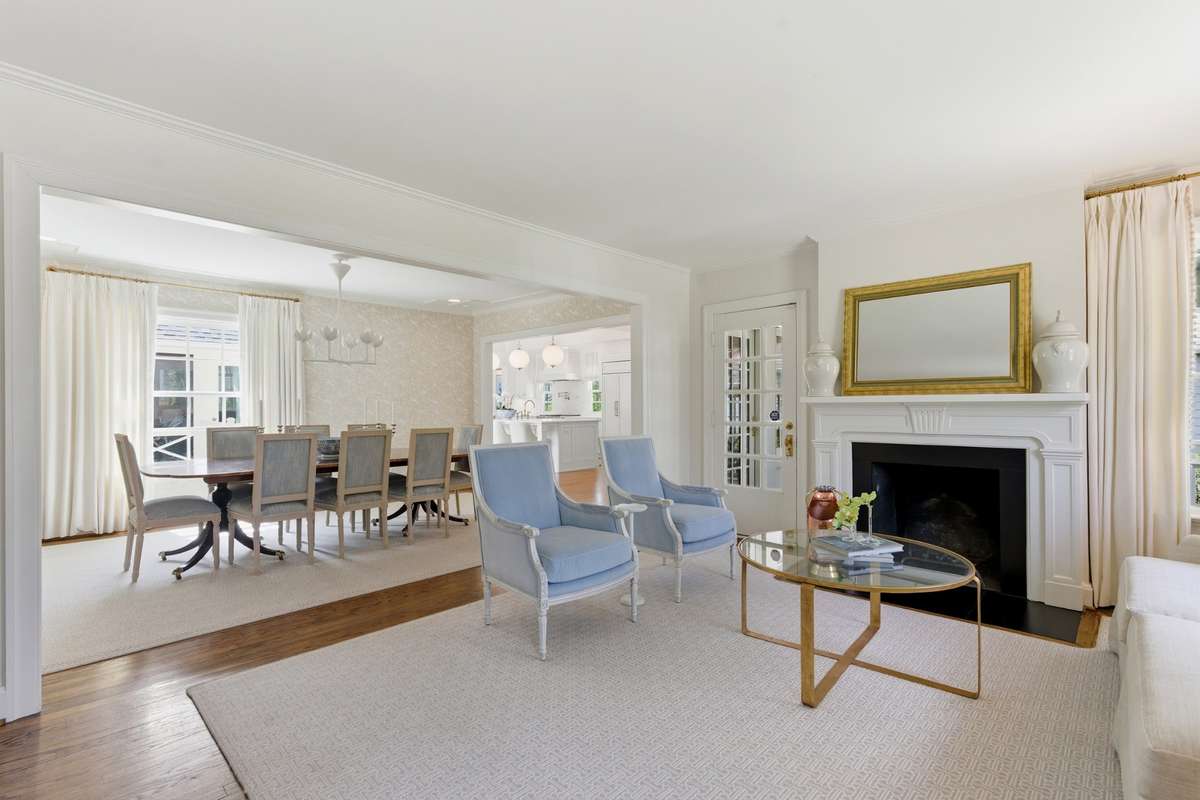 This formal living room boasts the original fireplace, gleaming hardwoods and opens to formal dining.
