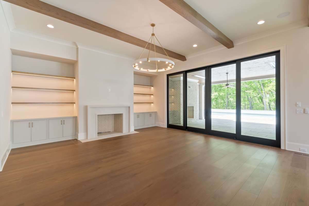 Great room with wood-burning fireplace opening up to outdoor living space.
