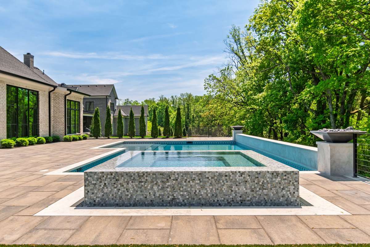 View of backyard with POOL & SPA backs up to mature tree line.