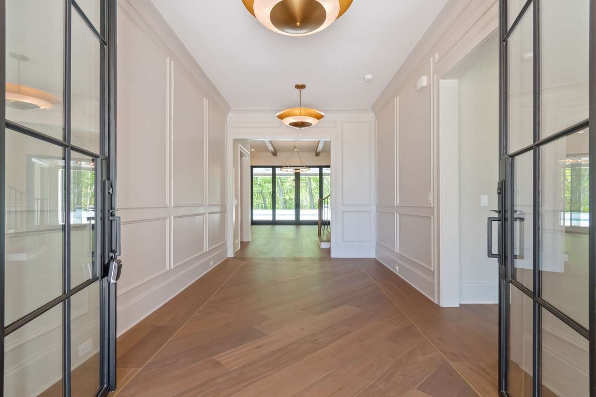 A grand foyer  with wall-to-wall wood detailing that invites you to explore the beauty within.