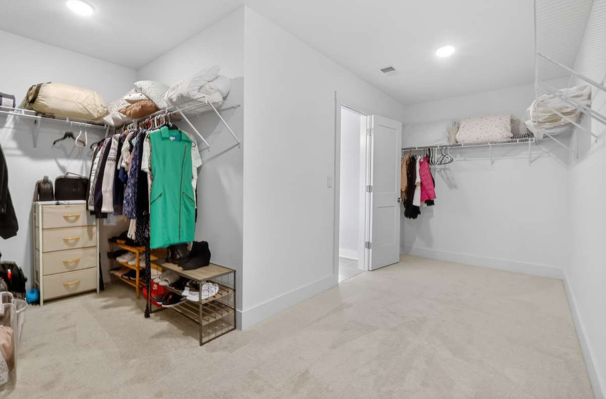 Large walk-in primary closet with ample storage space.