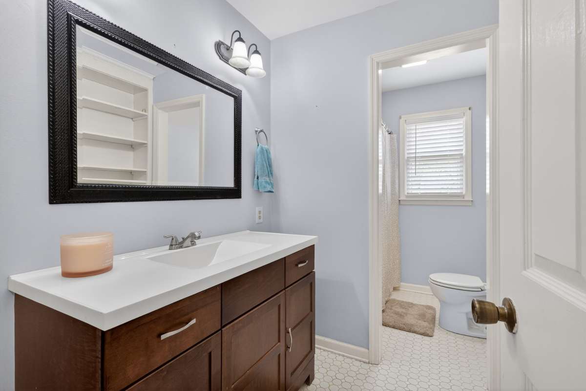 Full hall bath with newer vanity and great built-in shelving behind the door.