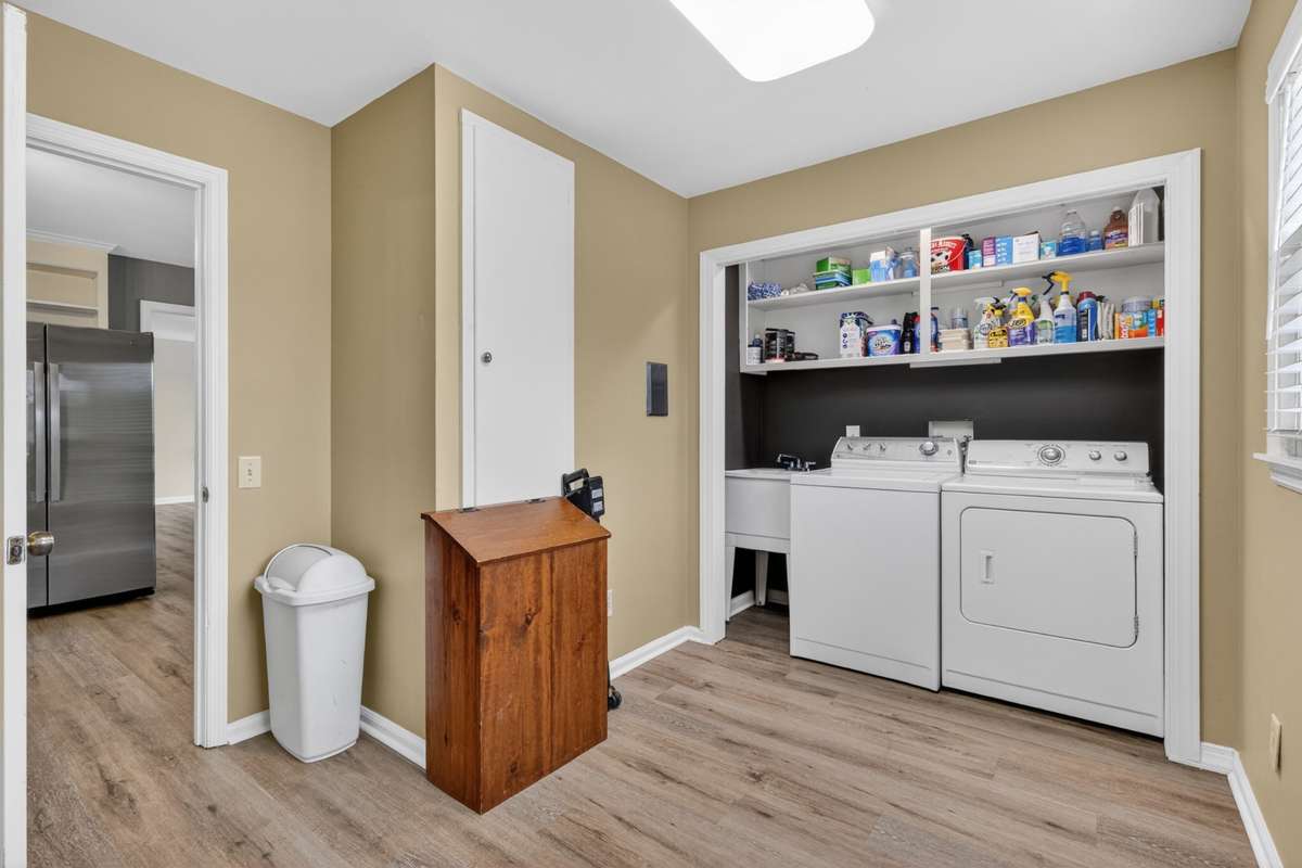Laundry Room with utility sink, lots of storage and room for an additional full-sized refrigerator. It even has a convenient built-in ironing board!