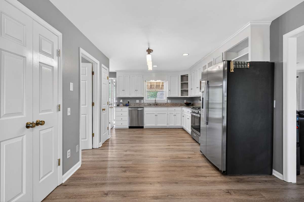 The Den is located to the right, and the doors on the left house two pantries. The open door is the Laundry Room. SO convenient.