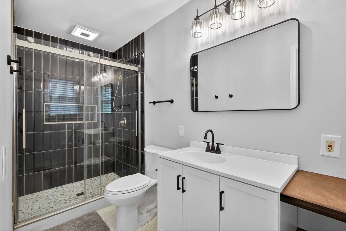 Gorgeous completely remodeled Primary Bath with tiled shower, gliding glass door, and built-in shelving for great storage. There is a Bluetooth system installed also!