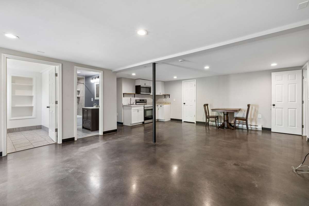 Fully finished basement featuring a convenient laundry area, full bathroom, and a second kitchen complete with stainless steel appliances.