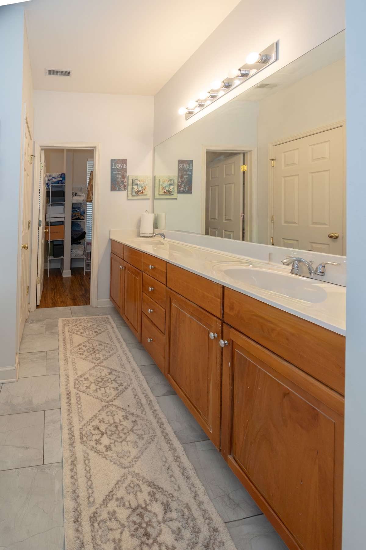 Primary bath with double vanity and large walk-in closet with built in shelves.