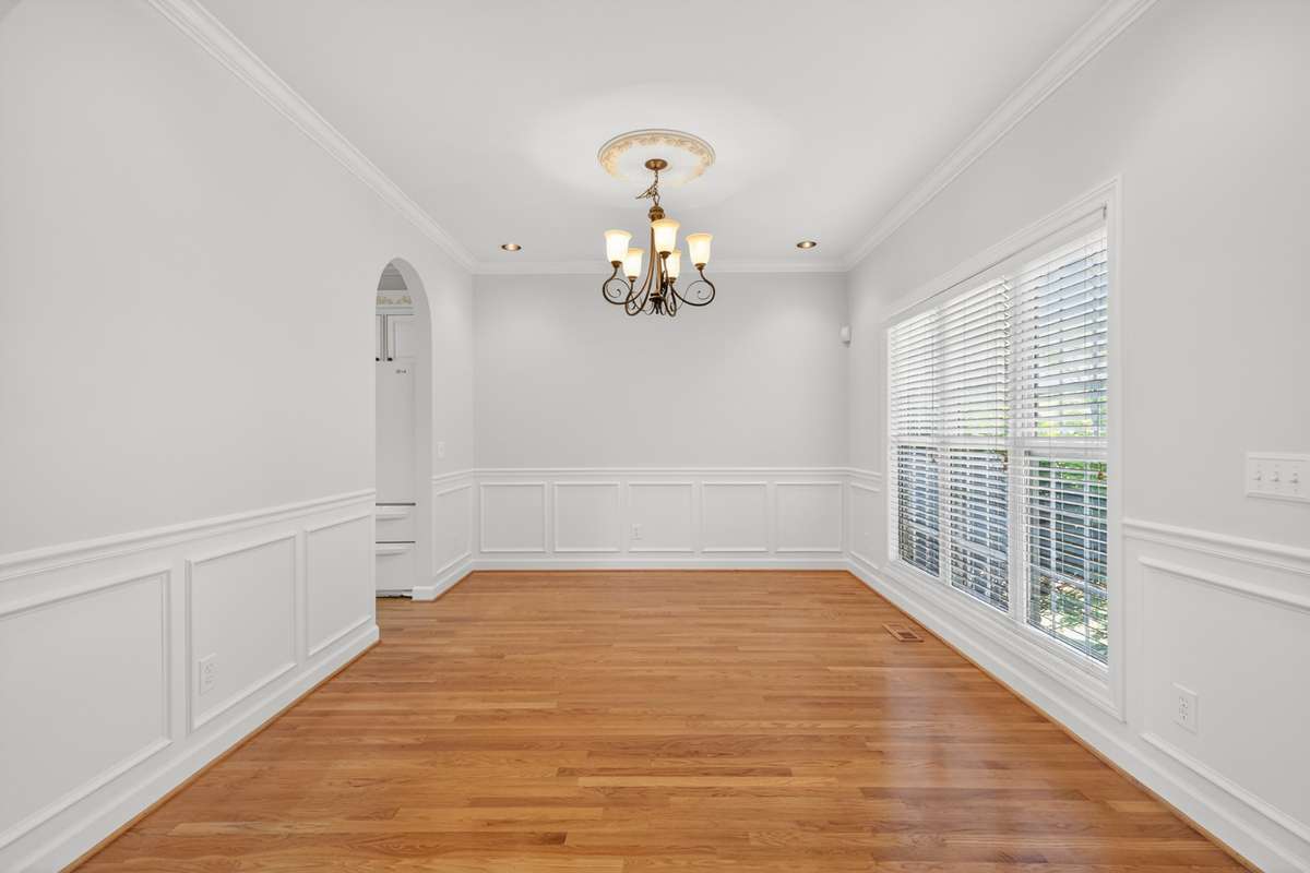 Dining Room with crown molding and wainscotting