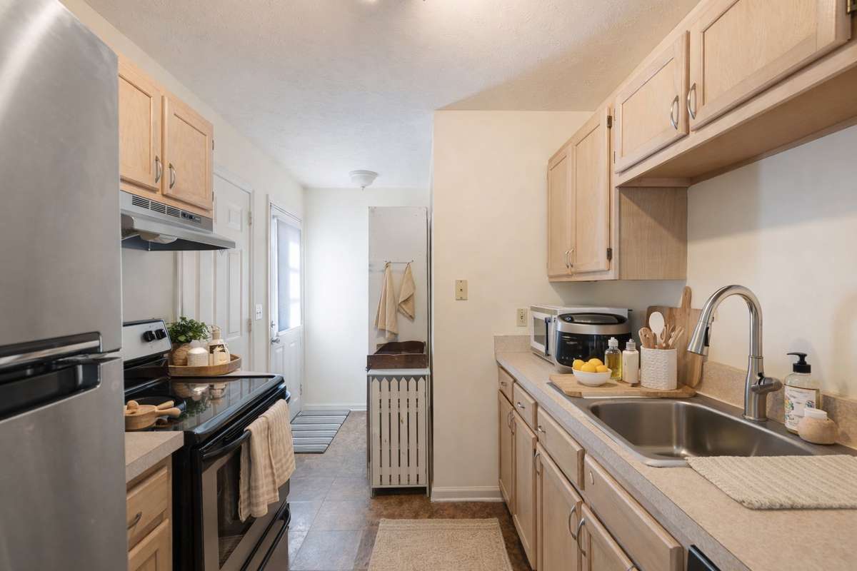 Kitchen includes stainless steel appliances, opens to the one car garage and side/backyard deck.