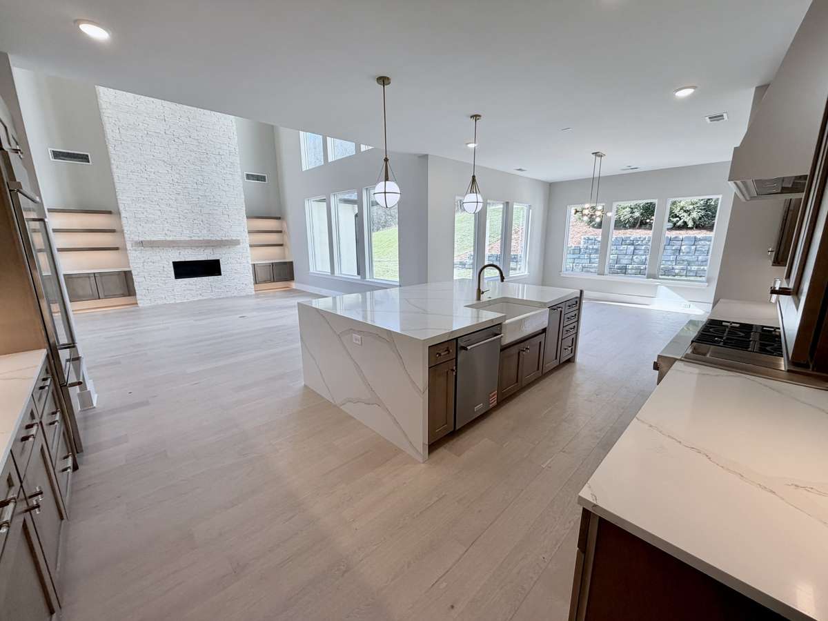 The chef’s kitchen unfolds seamlessly into a sun-drenched breakfast and casual dining space, all anchored by a breathtaking two-story great room, designed for connection and conversation. Actual Home Photo.