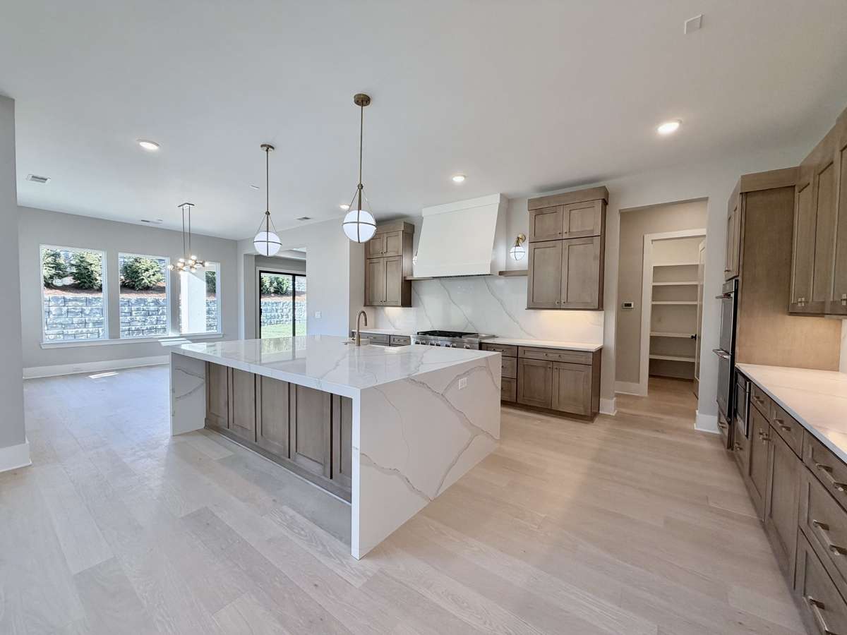 The gourmet kitchen, inviting great room, and exceptional main level recreational spaces & outdoor living are the perfect environment for hosting family and friends. Actual Home Photo.