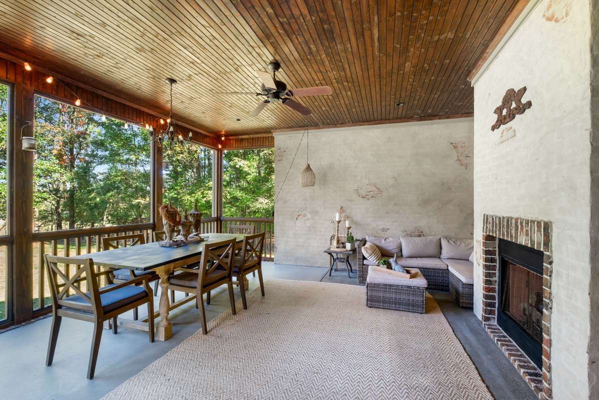 Screened-in porch with gas fireplace for al fresco dining and entertaining