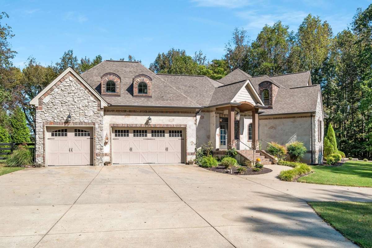 3 car garage off the side with ample additional surface parking for 3+ vehicles plus an additional two spaces by the front door