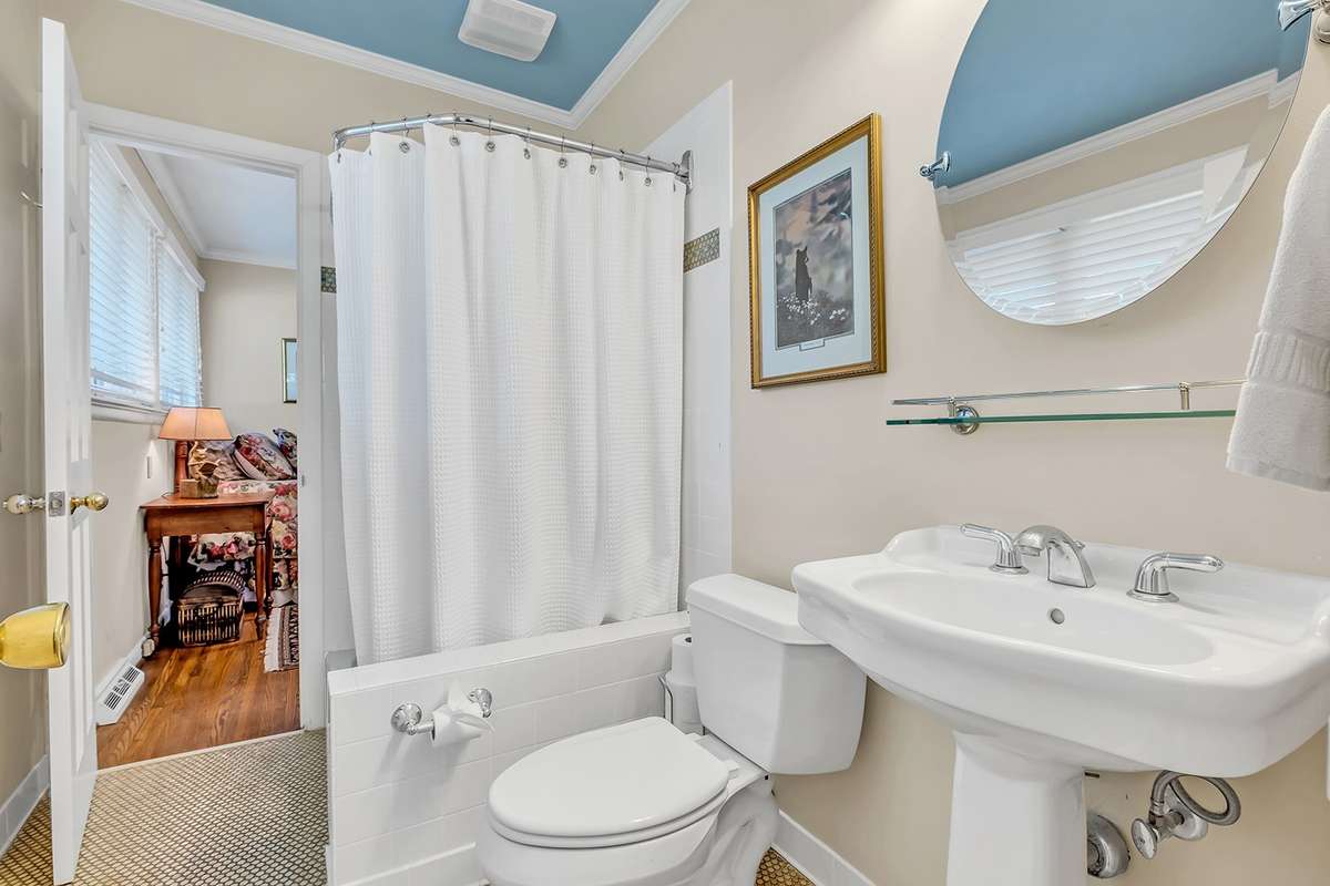 Jack-and-Jill bath w/vintage-style penny tile floor, tile shower w/foot bath