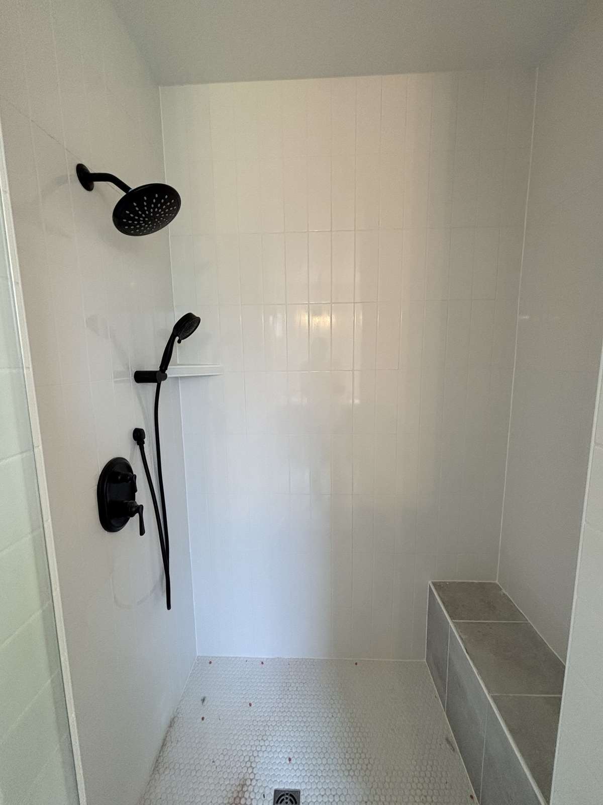 walk in tiled shower with bench