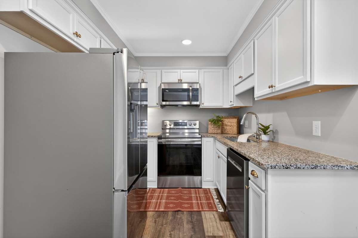 he kitchen shines with stainless steel appliances, including a side-by-side refrigerator with ice and water, along with elegant granite and quartz countertops.