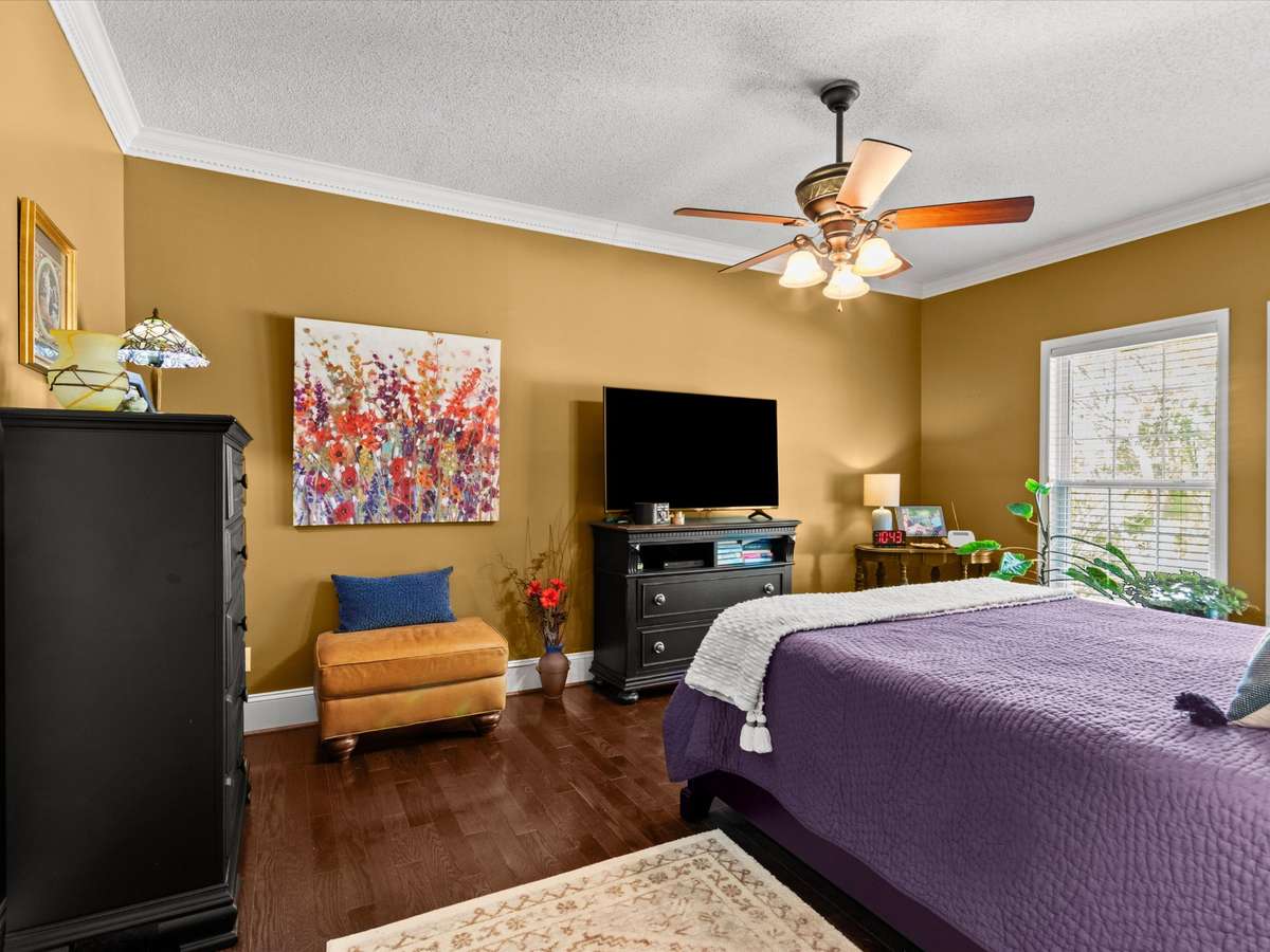 Primary Bedroom- Wood flooring, crown molding, ceiling fan, 9' ceiling