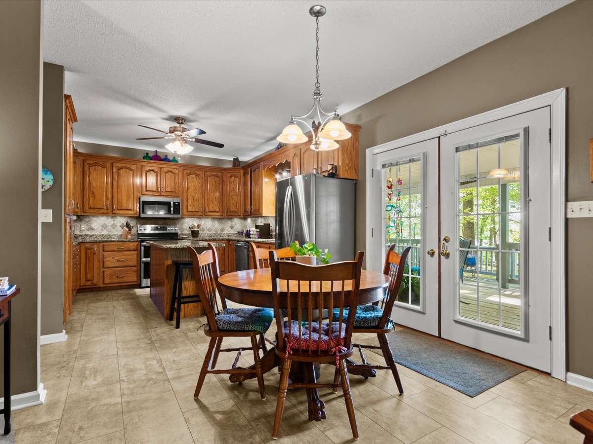 Breakfast room- LVP flooring, wood cabinetry, ceiling fan, tile backsplash, stainless steel appliances, kitchen island, 9' ceiling