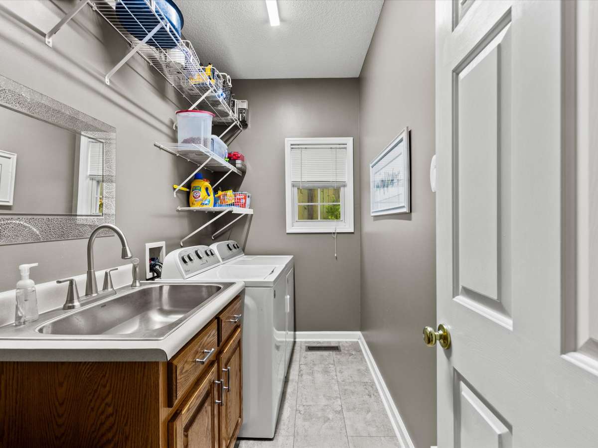 Laundry Room- LVP flooring, wire shelving, utility sink, washer/dryer connections