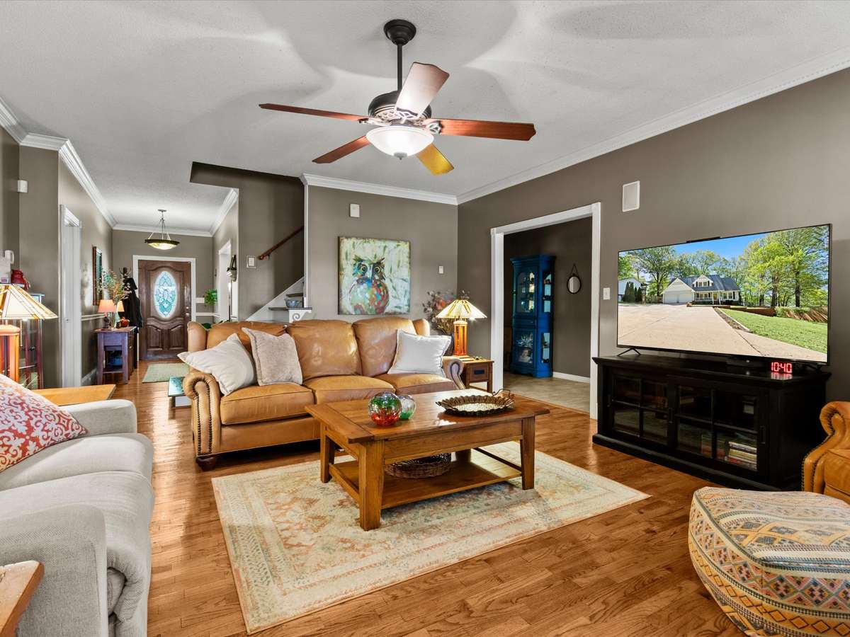 Living Room- Wood flooring, crown molding, ceiling fan, fireplace