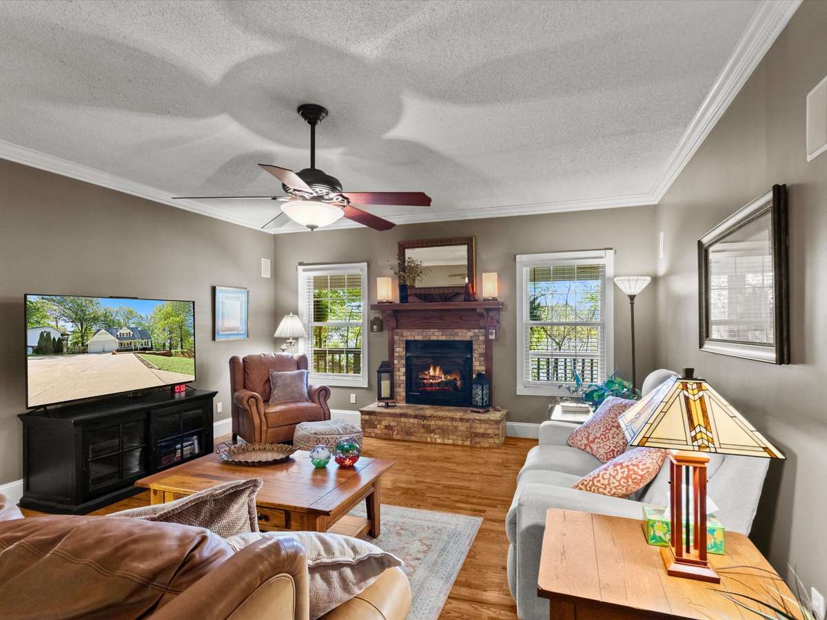 Living Room- Wood flooring, crown molding, ceiling fan, fireplace