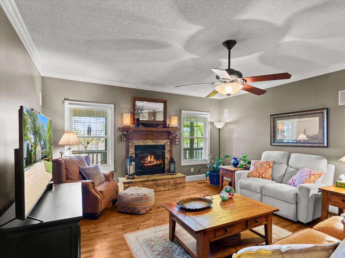 Living Room- Wood flooring, crown molding, ceiling fan, fireplace