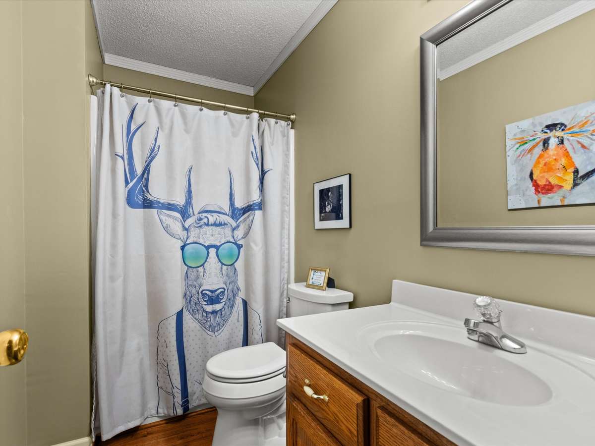 Full Bathroom- wood flooring, crown molding, tub/shower combo