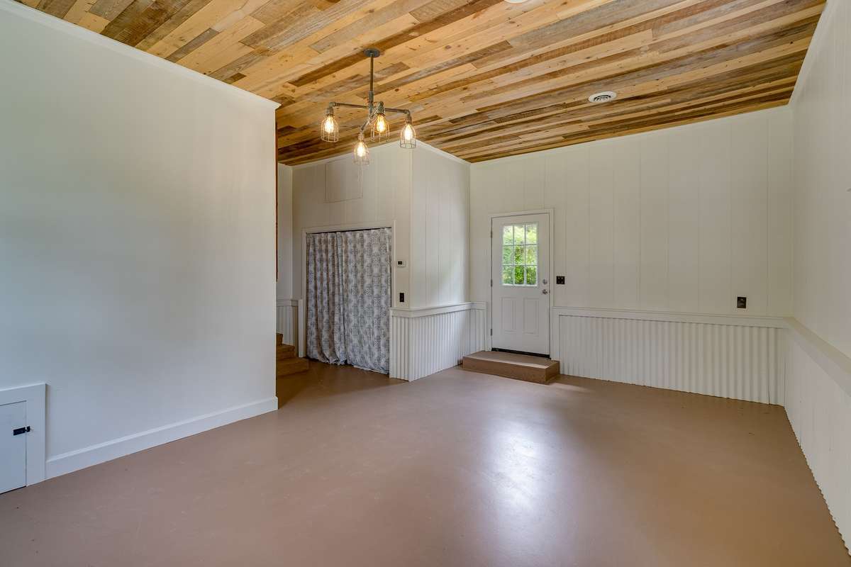 Currently utilized as a bonus room. The door enters directly from the driveway. This room could easily be converted back into a garage for a projected cost of $10k. Laundry is located behind the curtains.