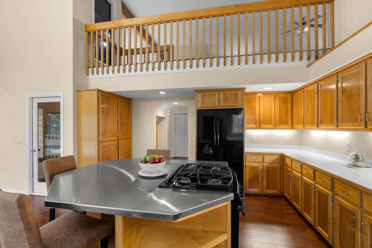 Kitchen with large island. Railing above is balcony from Bonus Room. Kitchen is 15 x 22.