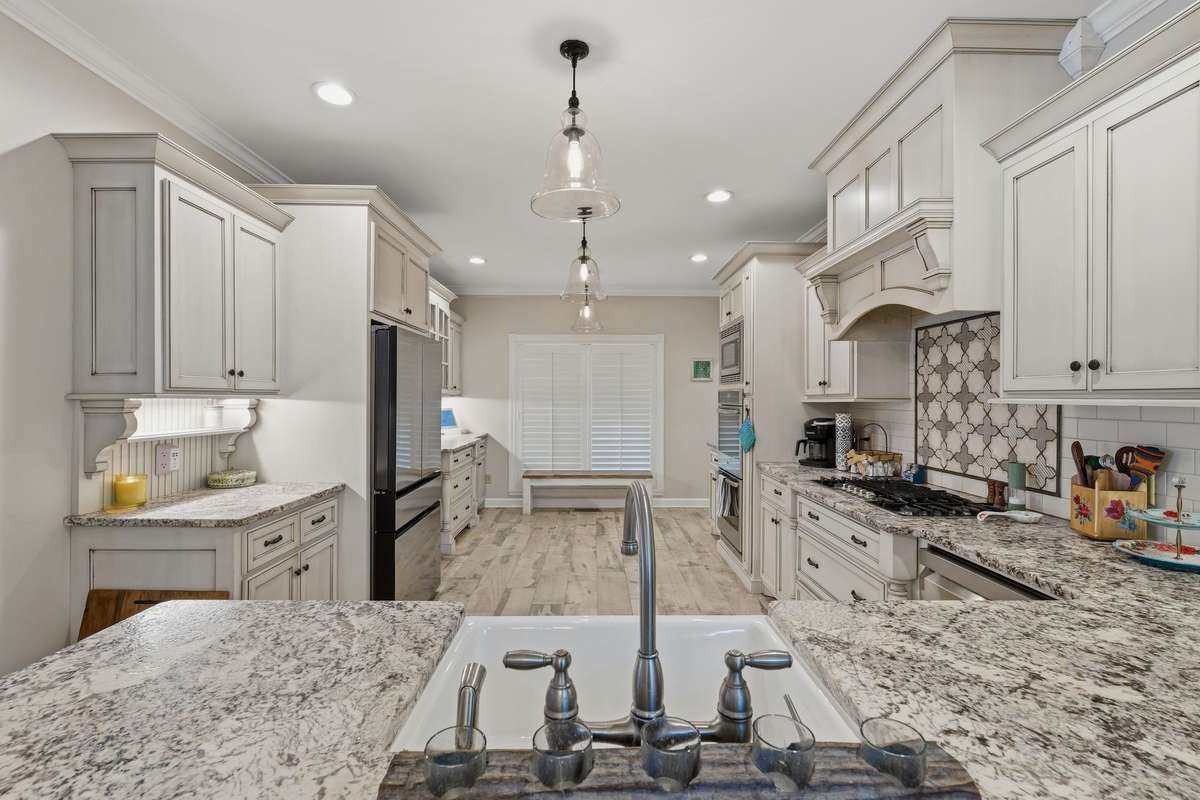 AND.... HERE IS YOUR DREAM KITCHEN!!  GORGEOUS CABINETRY AND GRANITE COUNTERS, WHITE DISTRESSED FLOORING... IT ALL; MAKES FOR AN ABSOLUTELY MESMERIZING LOOK.