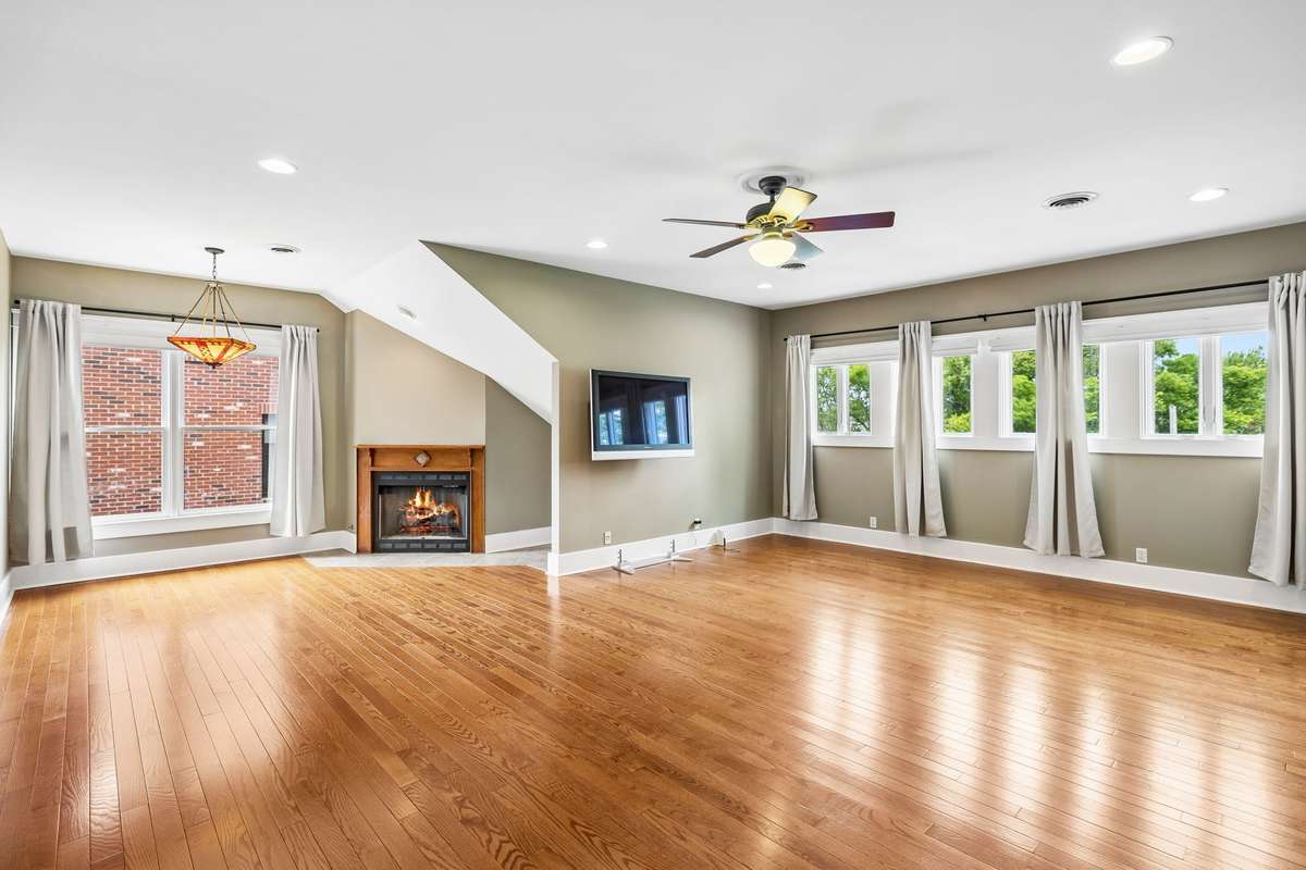 Retreat-like upstairs primary suite with a comfortable seating area and warm fireplace, creating the perfect space to unwind