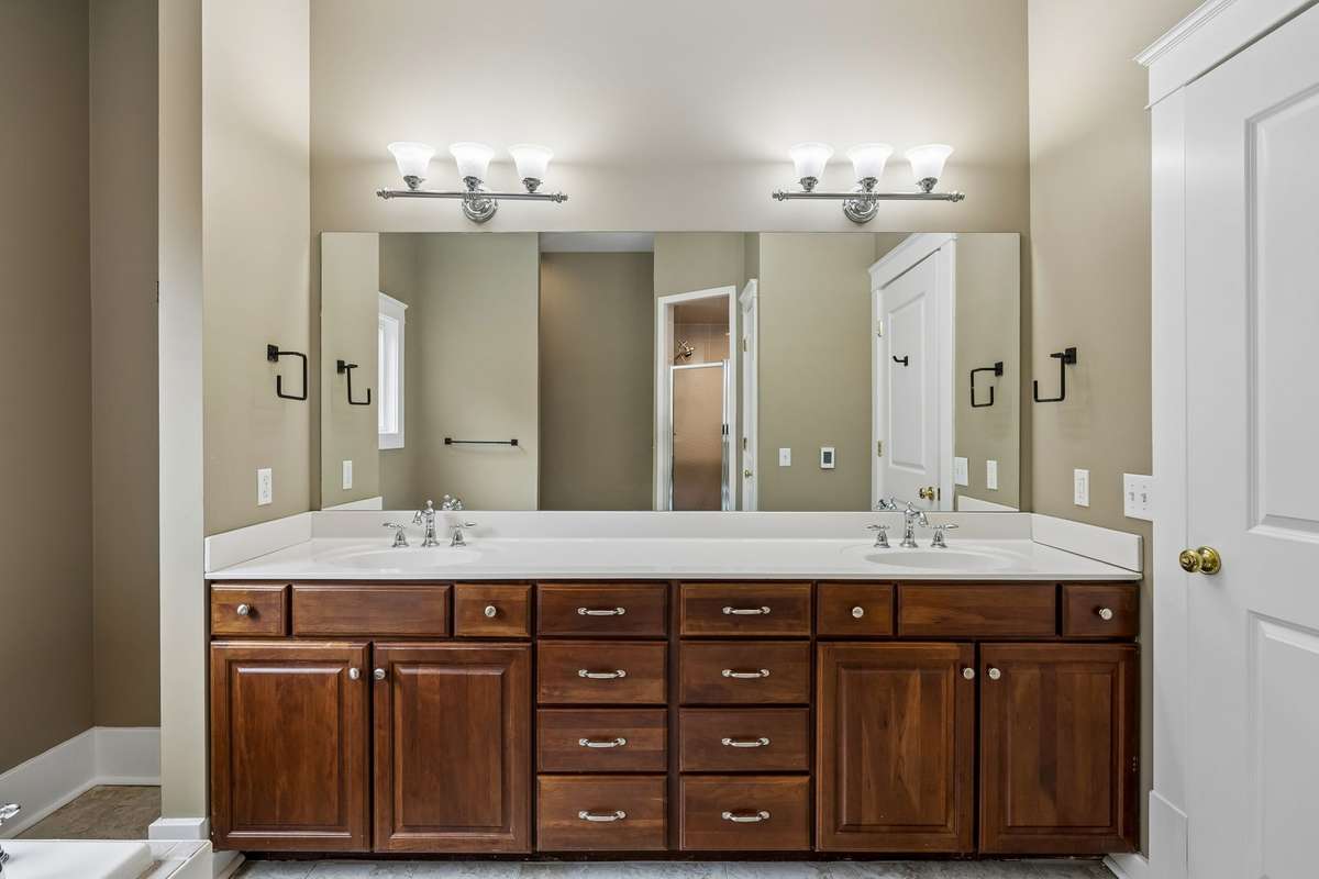 Luxurious bathroom retreat featuring dual vanities, a Jacuzzi tub, separate walk-in shower, and heated floors for ultimate comfort