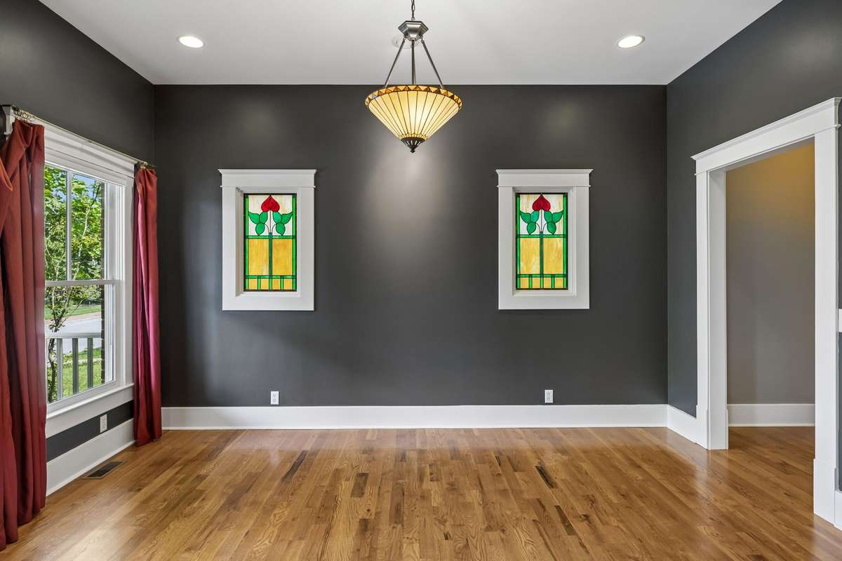 A formal dining room full of character, featuring matching stained glass that ties seamlessly with the living room