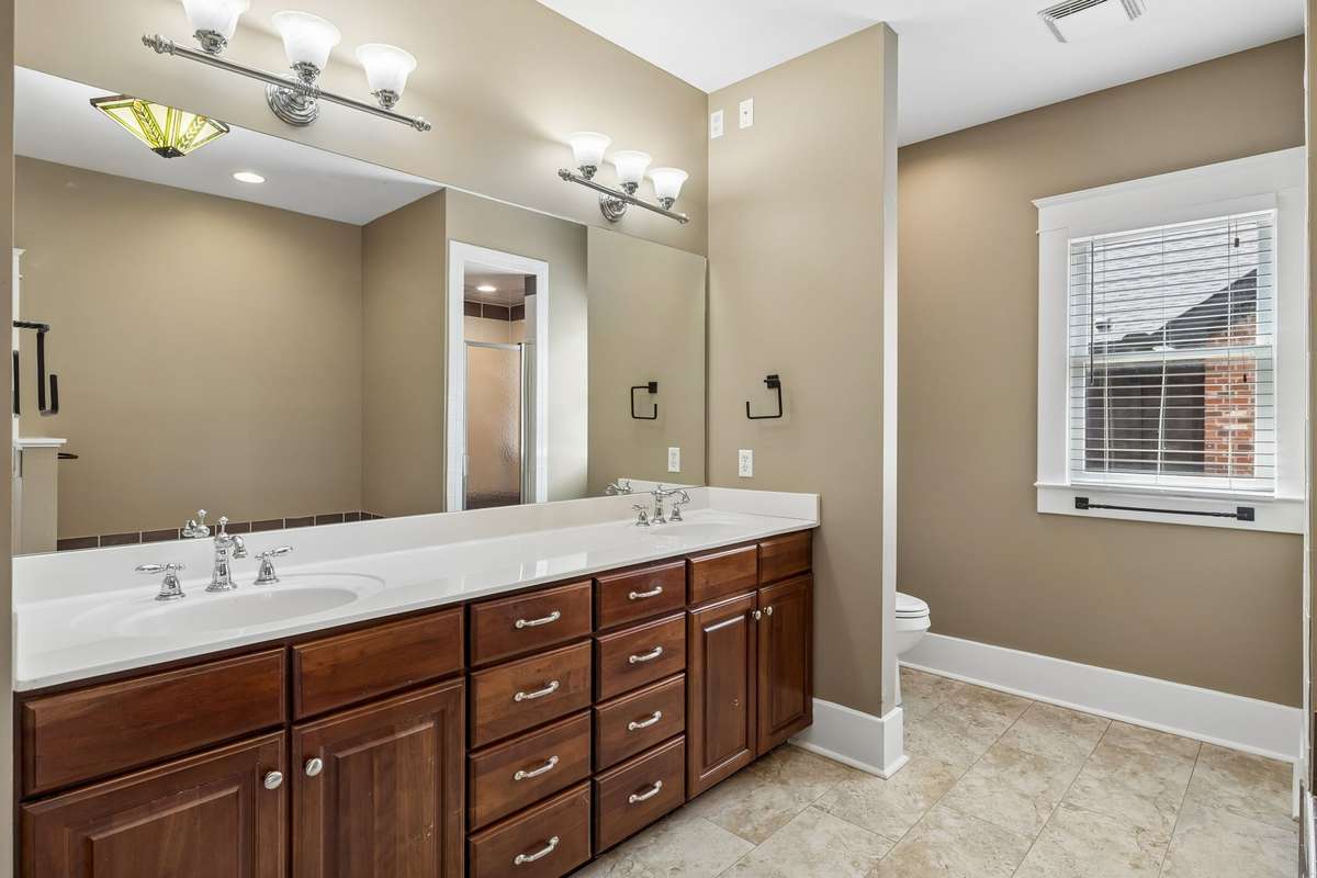 Spa-like bathroom with dual vanities, a relaxing Jacuzzi tub, separate walk-in shower, and heated floors